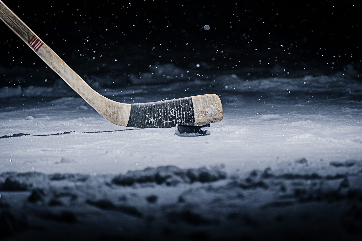 Hockey stick and puck on ice.
