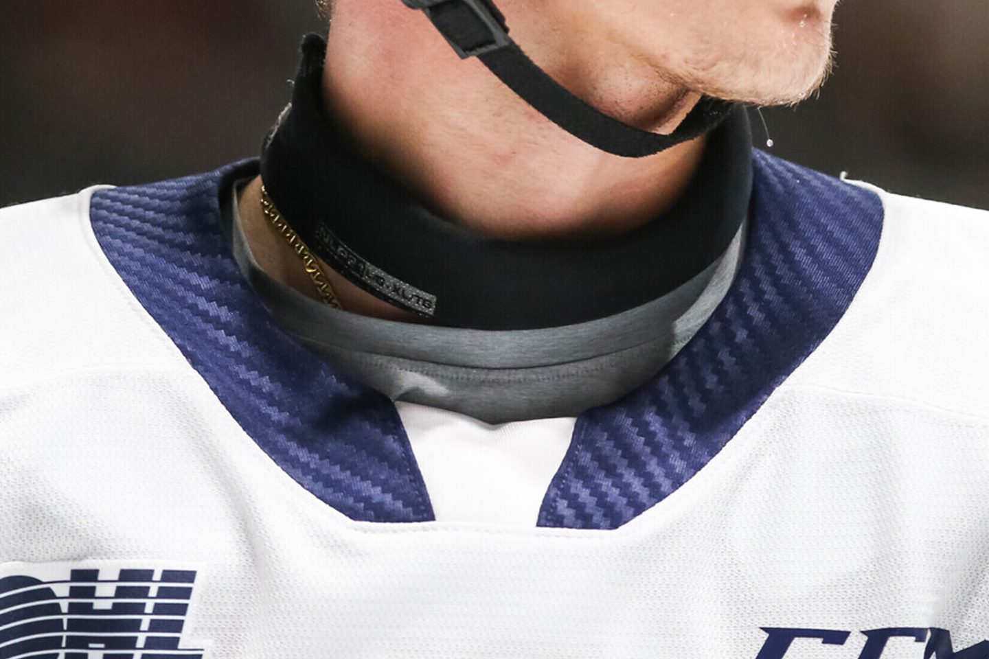 Hockey player wearing protective neck guard.