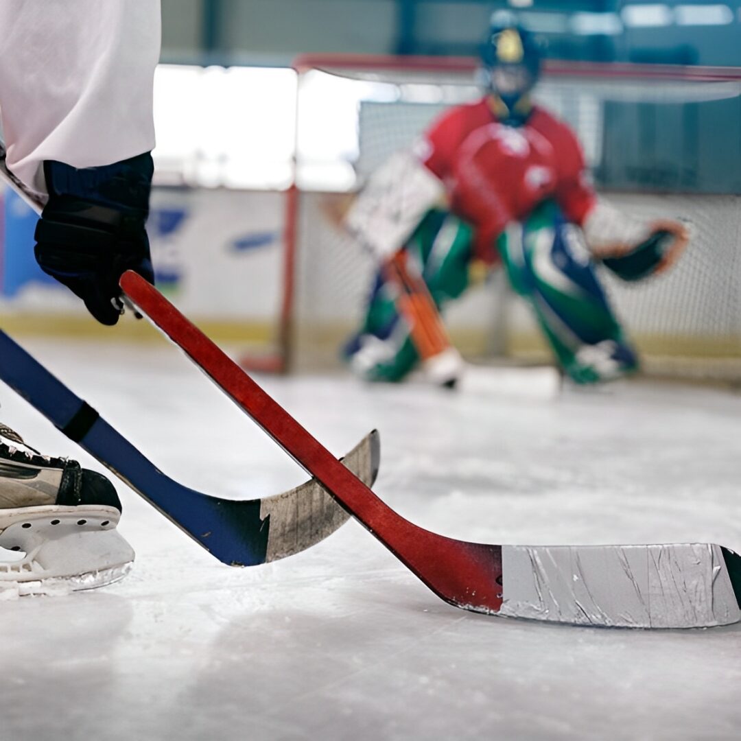 Hockey player with stick near goalie.