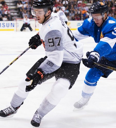 Two hockey players competing on ice rink.